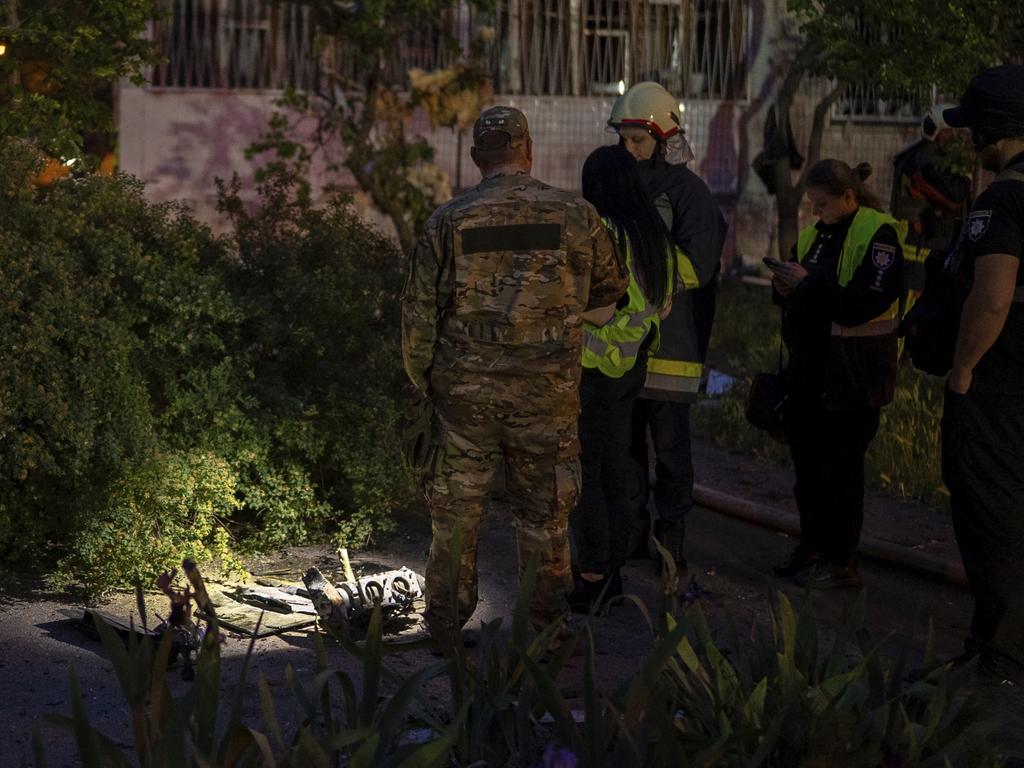 Officers investigate fragments of a Russian drone at the site of a residential building damaged in the attack on Kyiv. Picture: Alex Babenko / AP