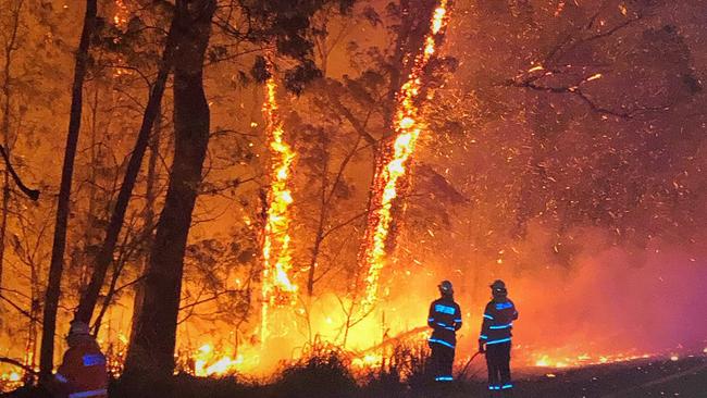 Firefighters take on the Currowan bushfire along the Princes Highway in Austinmer on Sunday night. Picture: AAP Image/Supplied by NSW RFS