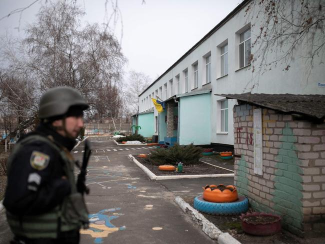 A Ukrainian soldier stands in a kindergarten after reported shelling in the settlement of Stanytsia Luhanska,on February 17, 2022. - U.S. Defense Secretary Lloyd Austin warned on February 17, 2022, of a provocation by Moscow to justify military intervention in Ukraine after "disturbing" reports of mutual accusations of bombing between the Ukrainian military and pro-Russian separatists. (Photo by Aleksey Filippov / AFP)