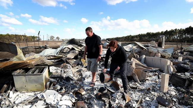 Phil and Maree Beasley standing in the burnt remains of their home in Terang, Victoria. Picture: Stuart McEvoy.