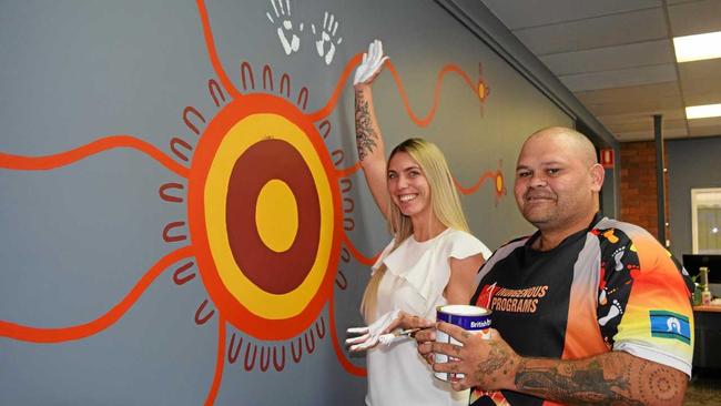 PAYING RESPECT: Sarah Peterson and artist Lionel Cubby at BEST employment in front of their new mural. Picture: Meg Bolton