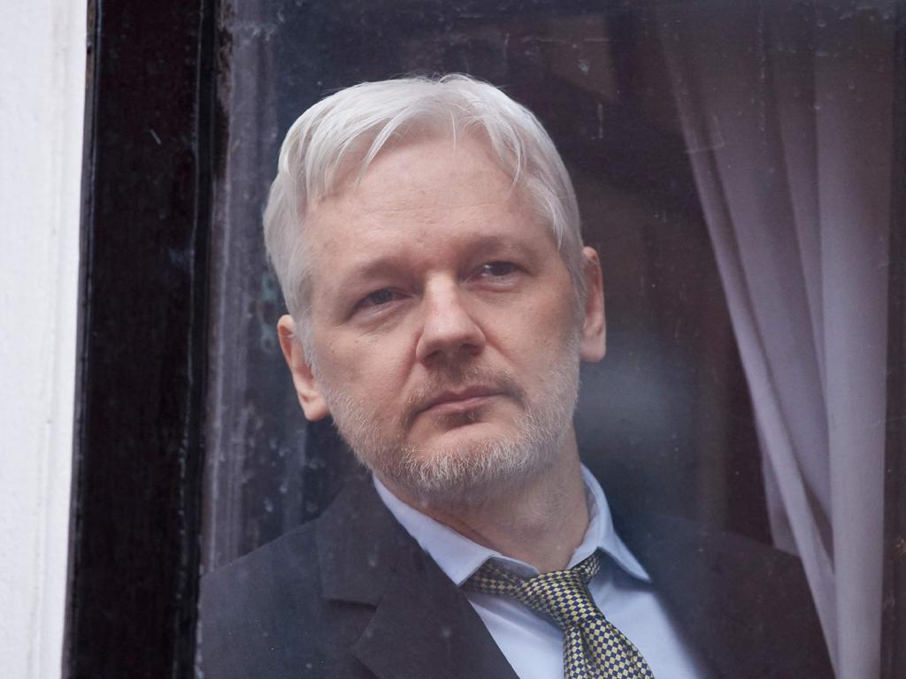 WikiLeaks founder Julian Assange is seen through the window of the door leading to the balcony of the Ecuadorean embassy in central London. Picture: AFP