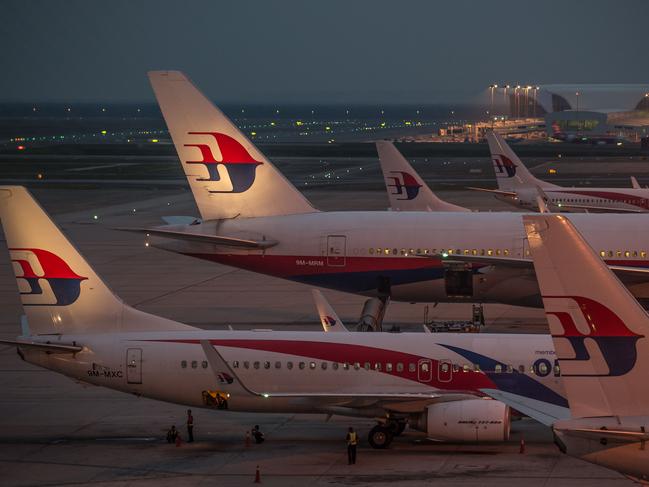 Ground staff prepare Malaysia Airlines planes for departure at Kuala Lumpur International Airport in Sepang on July 30, 2014. The remains of Flight MH17 victims will be handed over to the Netherlands, while Malaysia will receive the doomed plane's black boxes after Kuala Lumpur struck a breakthrough deal with Ukrainian separatists on July 22. AFP PHOTO / MOHD RASFAN