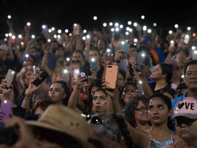 People hold up their phones during a prayer and candle vigil in El Paso following a shooting that left 20 people dead. Picture: AFP