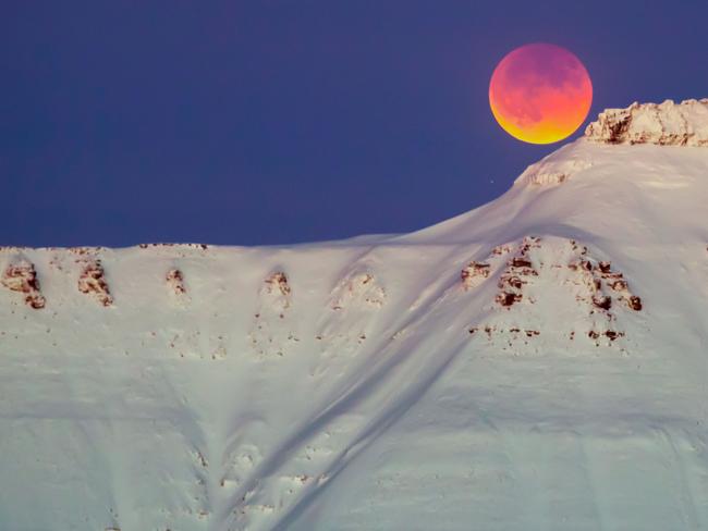 A super blue blood moon behind a mountain is seen from Longyearbyen, Svalbard, Norway. Picture: AFP