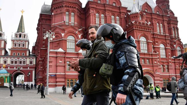 Police officers detain a man during a protest against Russian military action in Ukraine in central Moscow. (Photo by AFP)