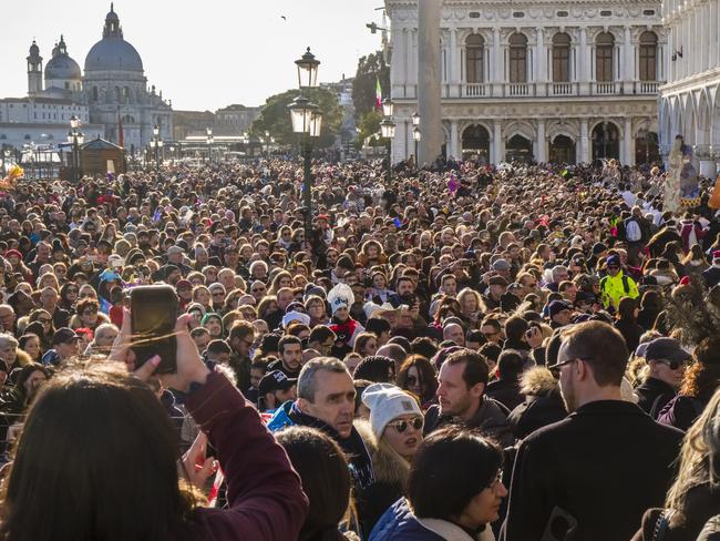 VENICE, VENETO, ITALY - 2019/02/23: Thousands of people are gathering along the Grand Canal, Canal Grande to celebrate the Venetian Carnival, the Basilica of Saint Mary of Health, Basilica di Santa Maria della Salute in the distance. (Photo by Frank Bienewald/LightRocket via Getty Images)