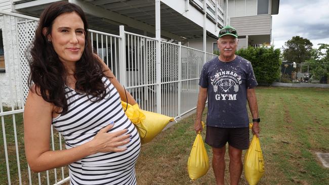 Pregnant Maryanne Sweet and her partner’s dad Merv Gardener do their best to prepare for the cyclone at Nudgee Beach. Picture: Annette Dew