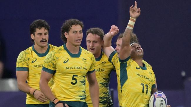 Australia players celebrate winning the men's quarter final rugby sevens match between Australia and USA during the Paris 2024 Olympic Games at the Stade de France in Saint-Denis on July 25, 2024. (Photo by CARL DE SOUZA / AFP)