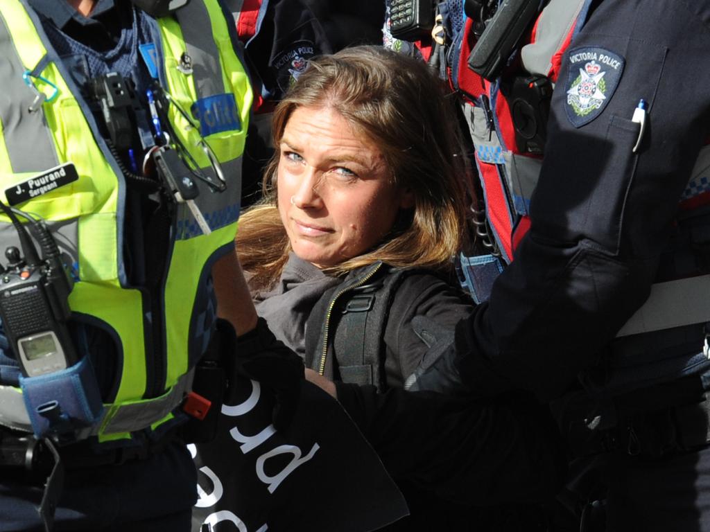 A woman is carried away by police. Picture: Andrew Henshaw