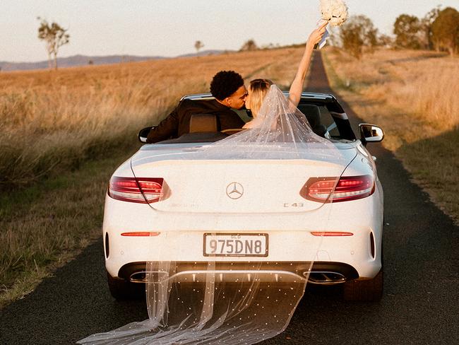 The wedding photo Miela had always wanted - in a convertible with veil trailing.