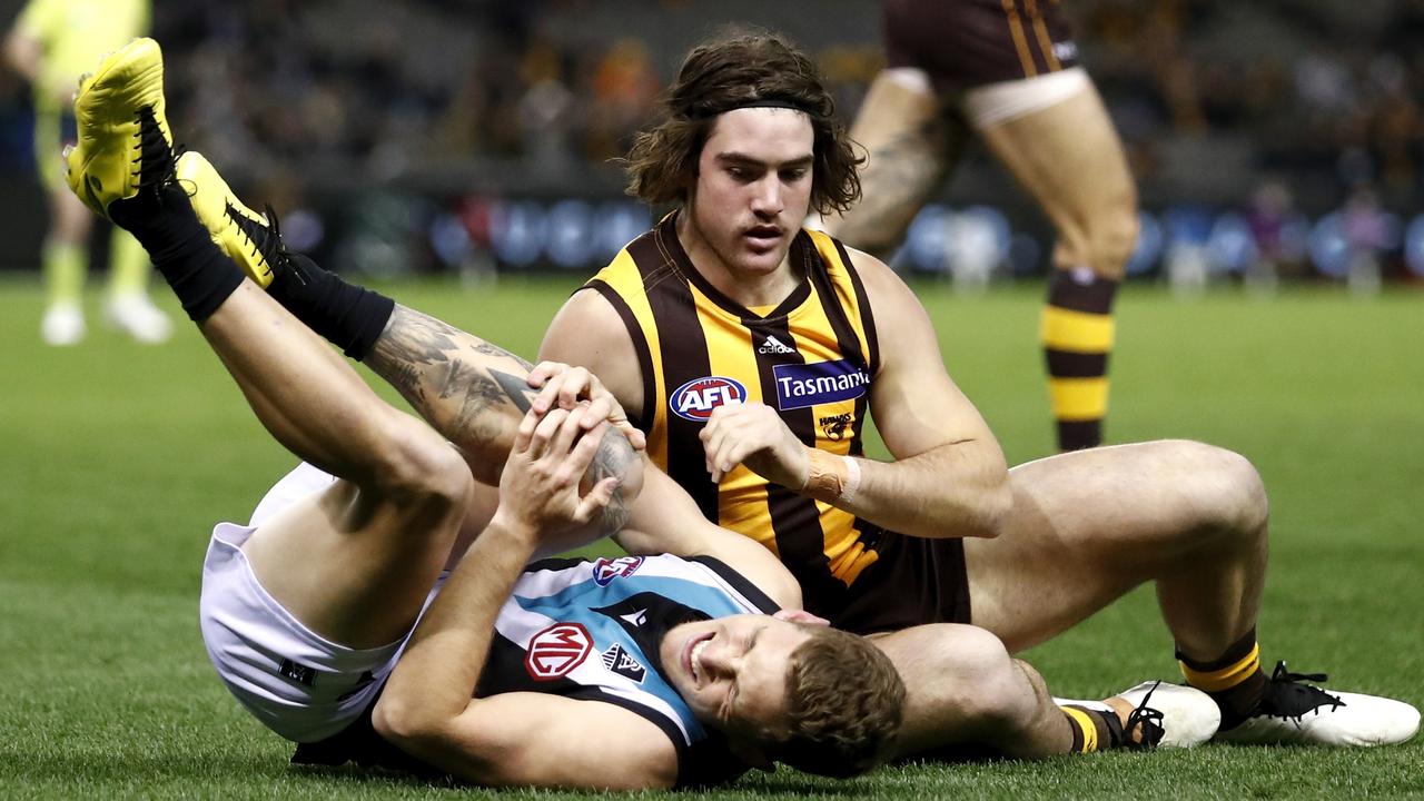 Kane Farrell clutches his knee after a tackle from Hawk Jai Newcombe. Picture: AFL Photos/Getty Images