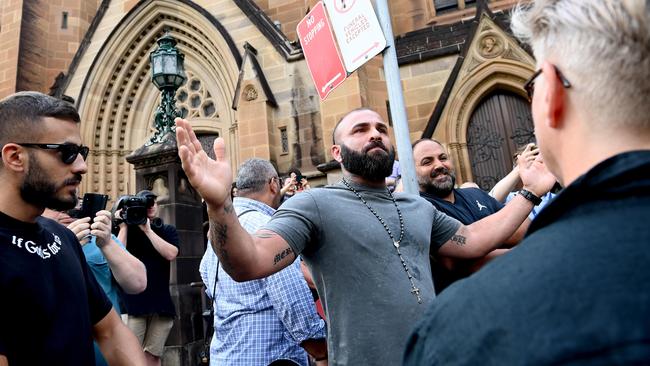 A man was moved on by police after he confronted protesters outside George Pell’s funeral on Thursday. Picture: NCA NewsWire / Jeremy Piper