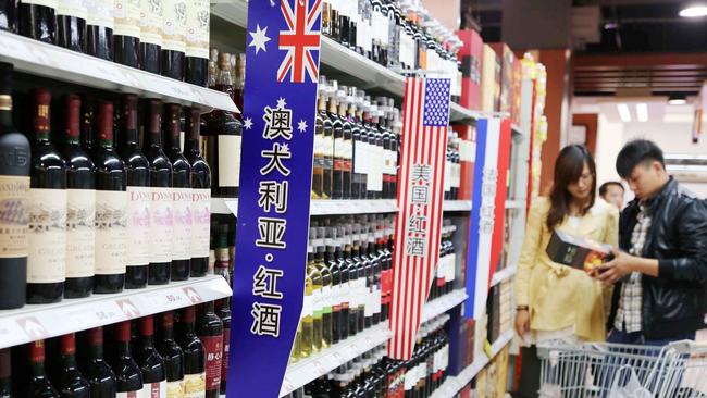 Chinese customers shop for wine imported from Australia at a supermarket in Xuchang city, central China's Henan province. Chinese buyers have developed a taste for more than just Australian stock of residential property and farmland, there's a renewed thirst for Australian wine and a 212 per cent tariff is poised to be relaxed. Picture: Reuters/AAP