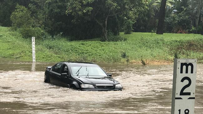 A Holden Commodore in floodwater on Hardys Road at Mudgeeraba. Picture: Glenn Hampson