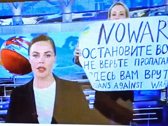 A man looks at a computer screen watching a dissenting Russian Channel One employee entering Ostankino on-air TV studio during Russia's most-watched evening news broadcast, holding up a poster which reads as "No War" and condemning Moscow's military action in Ukraine in Moscow on March 14, 2022 . - As a news anchor Yekaterina Andreyeva launched into an item about relations with Belarus, Marina Ovsyannikova, who wore a dark formal suit, burst into view, holding up a hand-written poster saying "No War" in English. (Photo by AFP)