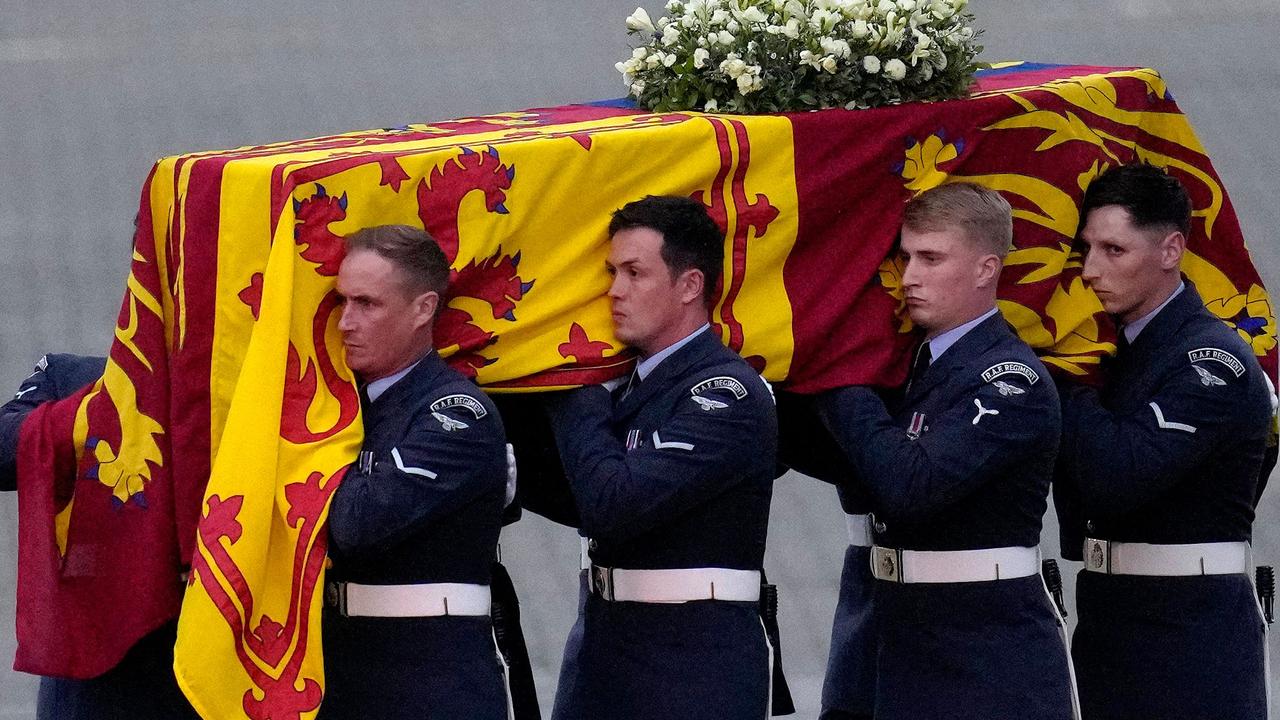 Pallbearers from the Queen's Colour Squadron (63 Squadron RAF Regiment) carry the coffin of Queen Elizabeth II to the Royal Hearse having removed it from the C-17 at the Royal Air Force Northolt airbase (Photo by Kirsty Wigglesworth / POOL / AFP)