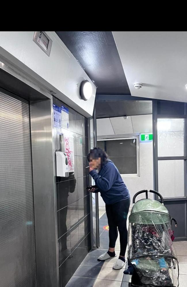 A woman with a pram lights a cigarette inside the towers at Elizabeth Street.