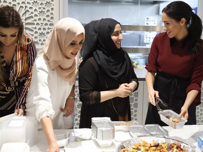 Meghan with some of the women who work at the community kitchen. Picture: Getty Images