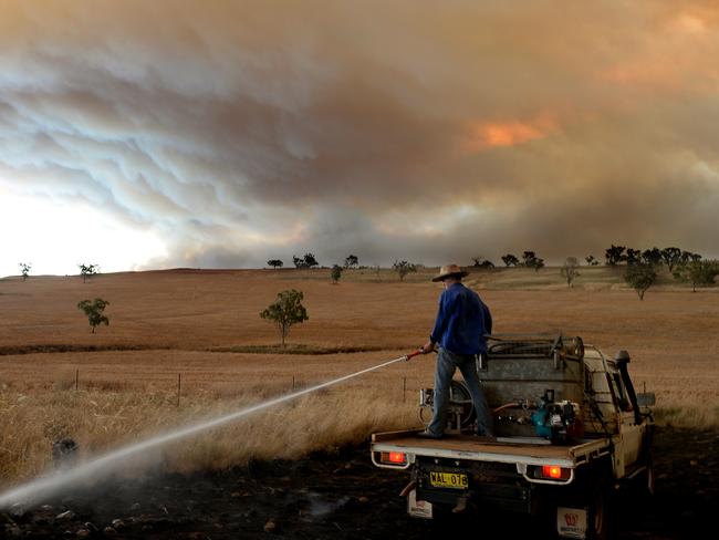 A local man works to extinguish a grass fire on the Golden Highway between Merriwa and Cassilis. Picture: Jeremy Piper
