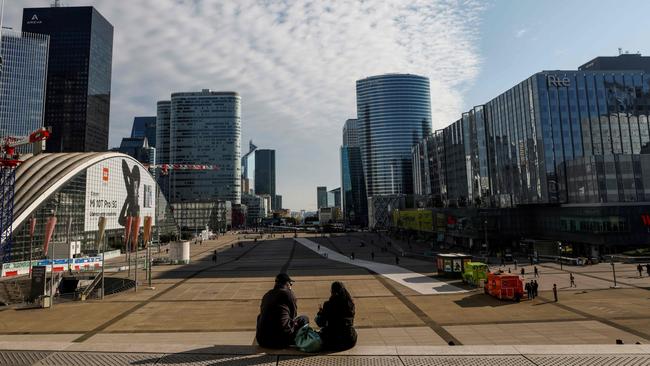 A couple sit on steps in La Defense Business District on the outskirts of Paris during a lockdown imposed by authorities in an attempt to halt the spread of Covid-19.