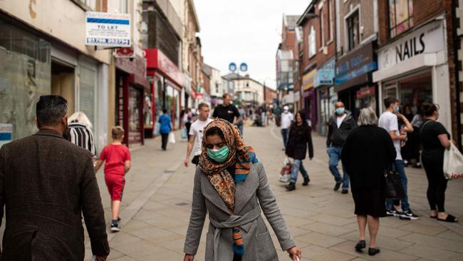 Shoppers are seen walking down a shopping strip in Oldham late last month. Picture: AFP