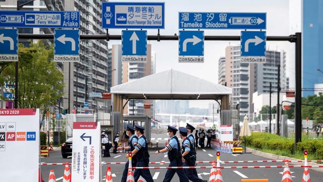 Policemen walk past one of the entrances to the Olympic Village in Tokyo. Picture: AFP