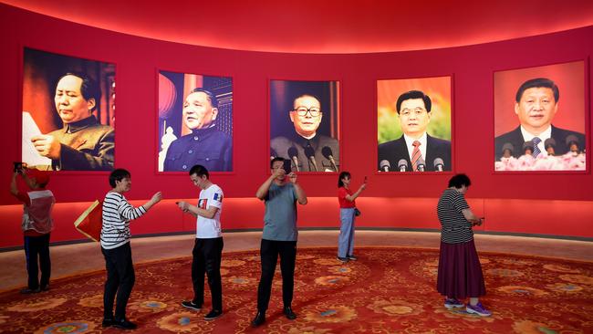 People take pictures in front of portraits of late Chinese chairman Mao Zedong and former Chinese leaders Deng Xiaoping, Jiang Zemin, Hu Jintao and current president Xi Jinping at an exhibition in Beijing marking the country's achievements over the past 70 years. Picture: AFP