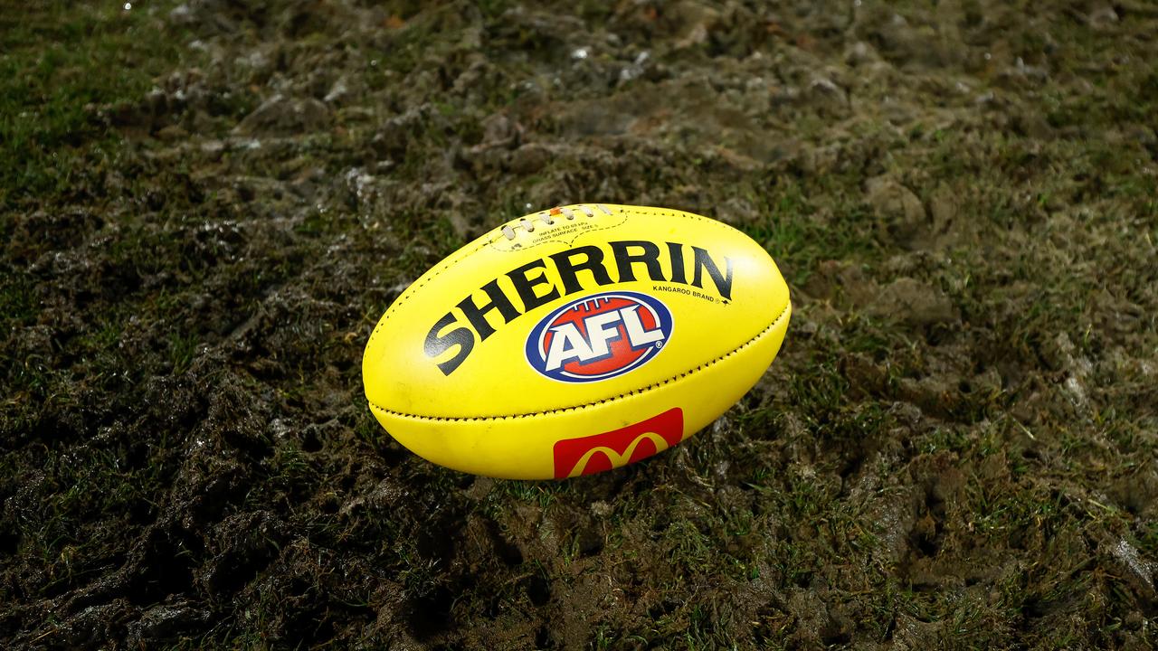 The yellow Sherrin football is seen in mud during the 2024 AFL Round 19 match between the Geelong Cats and the Western Bulldogs at GMHBA Stadium (Photo by Michael Willson/AFL Photos via Getty Images)