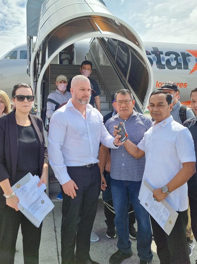 Australian and Indonesian officials to the side of the plane that would take the group back to Australia. Picture: Indonesian government