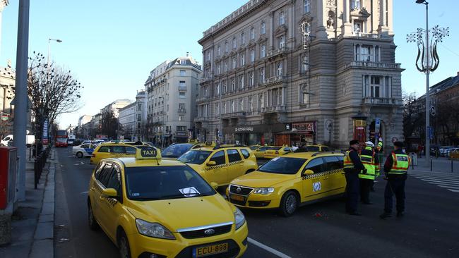 Hungarian police officers control the traffic in downtown Budapest on January 18, 2016 during a taxi drivers' demonstration againts Uber application. / AFP / FERENC ISZA