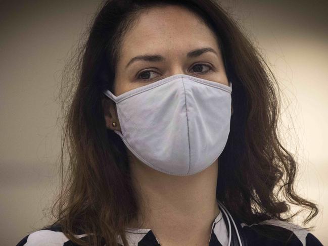 SYDNEY, AUSTRALIA - NewsWire Photos FEBRUARY 13, 2021: A woman wearing a cloth mask looks on in the baggage claim area for Virgin Australia flight 827 from Melbourne at Sydney Airport in Mascot after Melbourne entered a fresh lockdown at midnight. Picture: NCA NewsWire / Jenny Evans