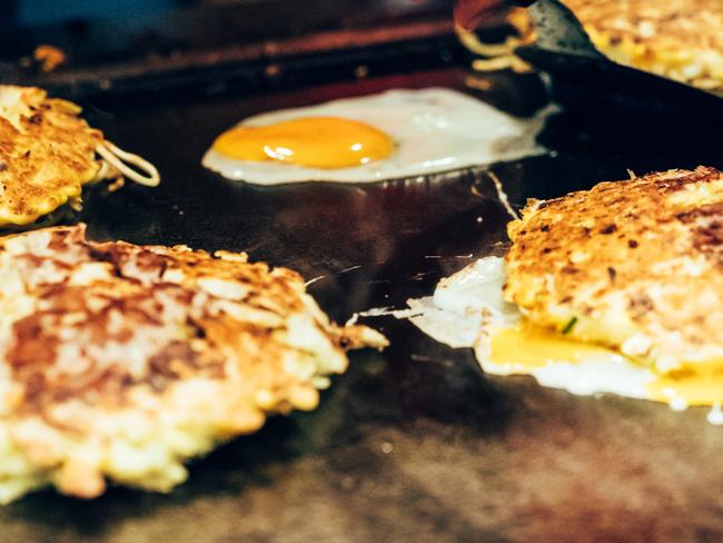 ESCAPE:  Hands of man take cooking of egg and noodles grill. Chef making delicious street food in Japanese teppanyaki restaurant. close up photo of tasty snack on hot iron plate. Picture: Istock