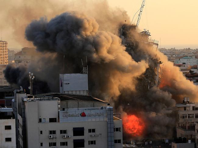 Heavy smoke and fire surround Al-Sharouk tower as it collapses during an Israeli air strike, in Gaza City. Picture: AFP