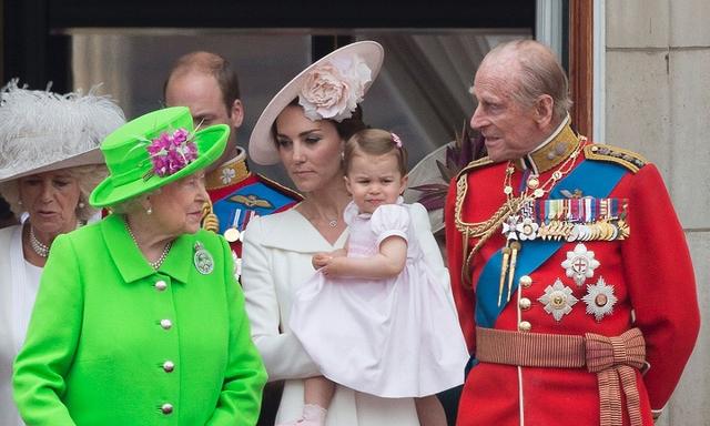 (L-R) Britain's Queen Elizabeth II, Britain's Catherine, Duchess of Cambridge holding her daughter Princess Charlotte and Prince Philip, Duke of Edinburgh watch a fly-past of aircrafts by the Royal Air Force, in London on June 11, 2016.  Trooping The Colour and the fly-past are part of a weekend of events to celebrate the Queen's 90th birthday. / AFP PHOTO / JUSTIN TALLIS