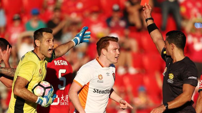 Michael Theo of Brisbane Roar is shown a red card by referee Stephen Lucas.