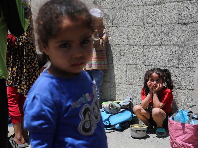Palestinian children wait near a charity kitchen distributing portions of cooked food at the Nuseirat refugee camp in the central Gaza Strip. Picture: AFP