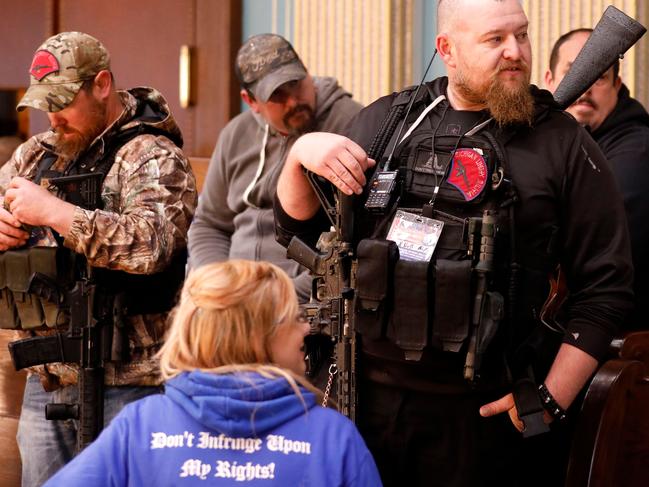 William Null (R) stands in the gallery of the Michigan Senate Chamber during the American Patriot Rally, organized by Michigan United for Liberty, to demand the reopening of businesses on the steps of the Michigan State Capitol in Lansing, Michigan, on April 30, 2020. Others are unidentified. - Thirteen men, including members of two right-wing militias, have been arrested for plotting to kidnap Michigan Governor Gretchen Whitmer and "instigate a civil war", Michigan Attorney General Dana Nessel announced on October 8, 2020. The Nulls were charged for their alleged roles in the plot to kidnap Whitmer, according to the FBI. The brothers are charged with providing support for terroristic acts and felony weapons charges. (Photo by JEFF KOWALSKY / AFP)