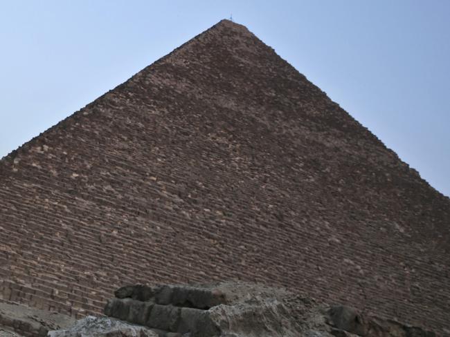 FILE - In this file photo dated Monday, Nov. 9, 2015, an Egyptian policeman walks near a pyramid in Giza, Egypt.  Egypt's Antiquities Ministry on Saturday Feb. 3, 2018, announced the discovery of a 4,400-year-old tomb near the pyramids outside Cairo. (AP Photo/Nariman El-Mofty, FILE)