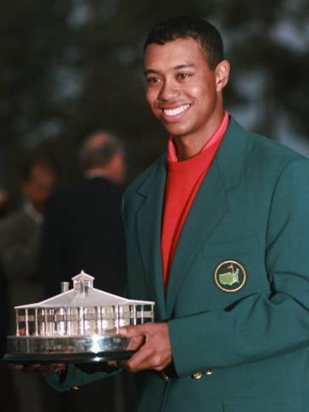 Tiger Woods holding a replica of the Masters Trophy after winning the golf tournament for the first time by a record 12 shots.