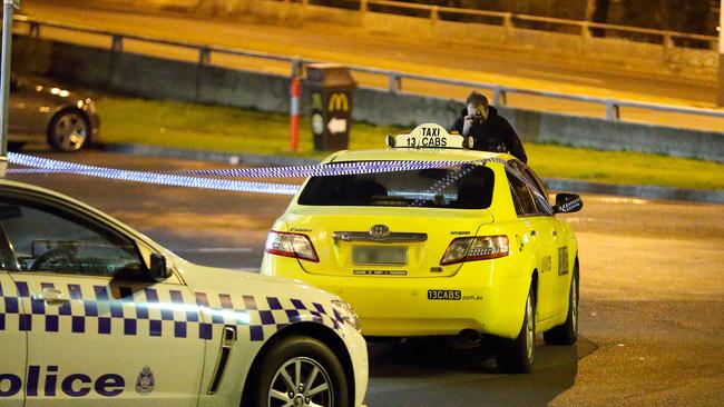 A detective photographs the taxi on Queens Parade. Picture: Patrick Herve