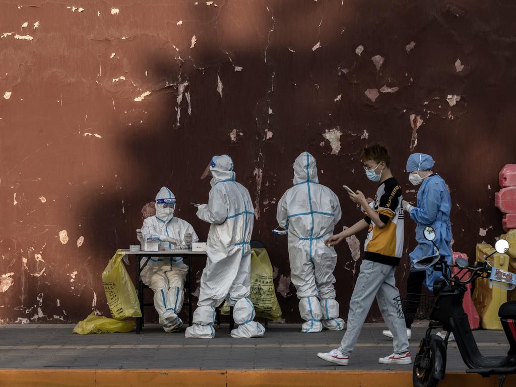 Health workers wear protective clothing as they gather at a makeshift nucleic acid testing site to detect Covid-19 outside the Lama Temple in Beijing, China. Picture: Getty Images