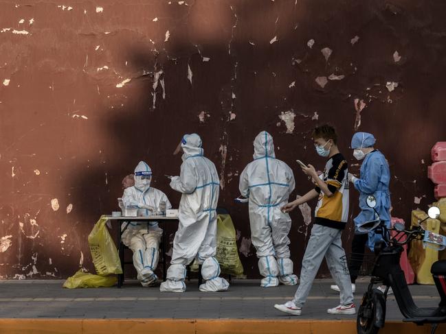 Health workers wear protective clothing as they gather at a makeshift nucleic acid testing site to detect Covid-19 outside the Lama Temple in Beijing, China. Picture: Getty Images