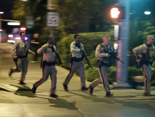 Police run to cover at the scene of a shooting near the Mandalay Bay resort and casino on the Las Vegas Strip. Picture: AP