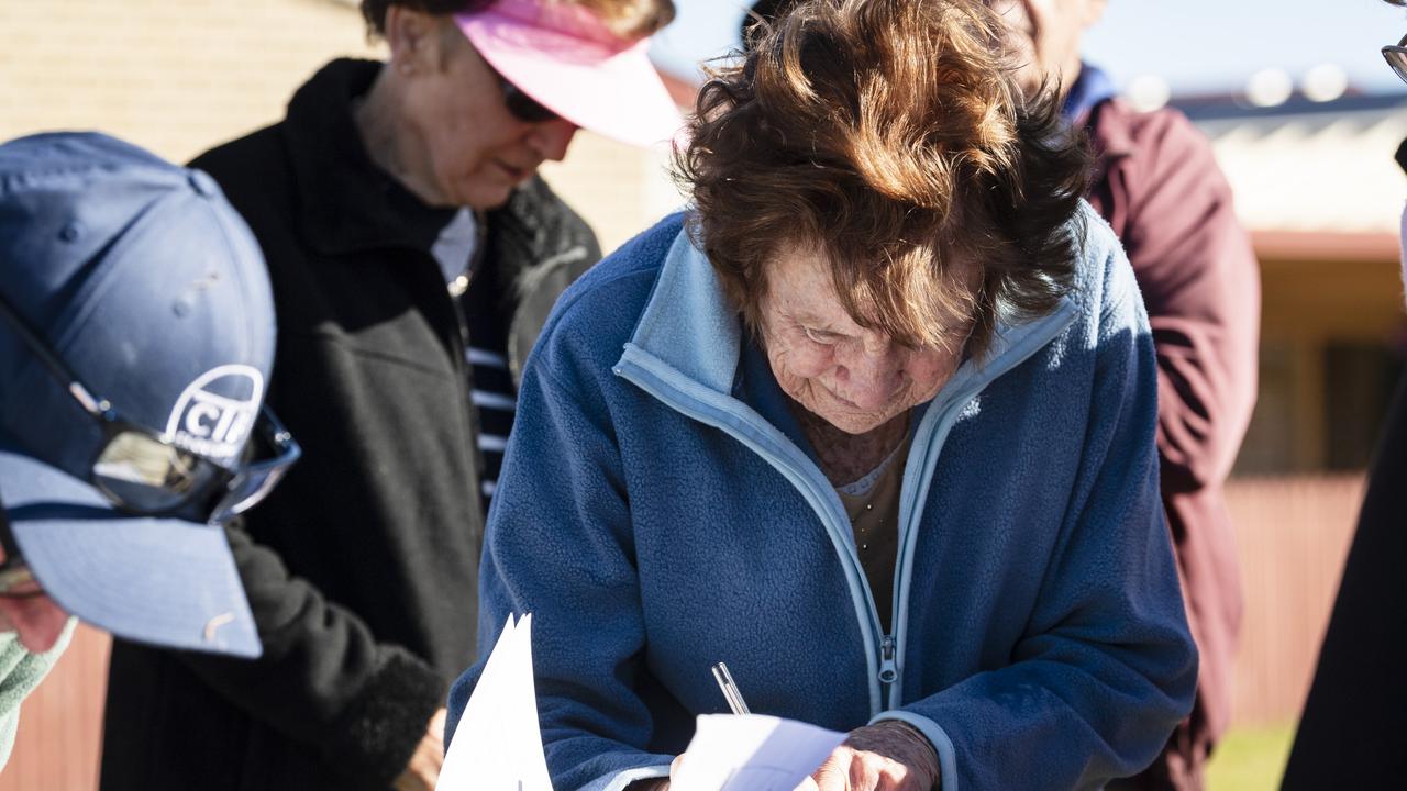 Wendy Chisholm signs the petition at a community meeting at Halsworth Street Park against proposed material change of use to create the Greenwattle Wellness Community development on Greenwattle St, Saturday, June 24, 2023. Picture: Kevin Farmer