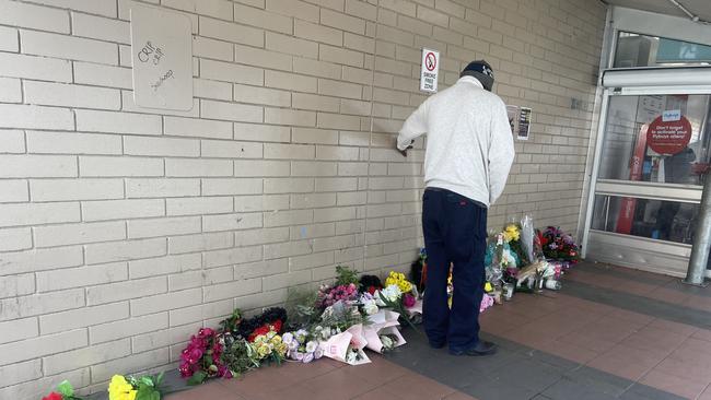 An Aboriginal man holds the wall where a memorial for a 24-year-old man is outside of Coles in Alice Springs. Picture: Gera Kazakov