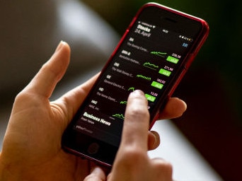 PRODUCTION - 24 April 2021, Berlin: A young woman uses her iPhone to monitor share prices in the Stocks app. Low interest rates and the ongoing stock market boom are also bringing more and more young people to the stock market. (to dpa "Influencers and Trading Apps: The Young Discover the Stock Market") Photo: Fabian Sommer/dpa (Photo by Fabian Sommer/picture alliance via Getty Images)