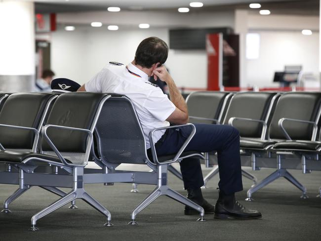 Tullamarine Airport arrivals and departures grinding down with the rest of Australian air travel. A pilot waits alone at the Qantas domestic departure lounge.     Picture: David Caird