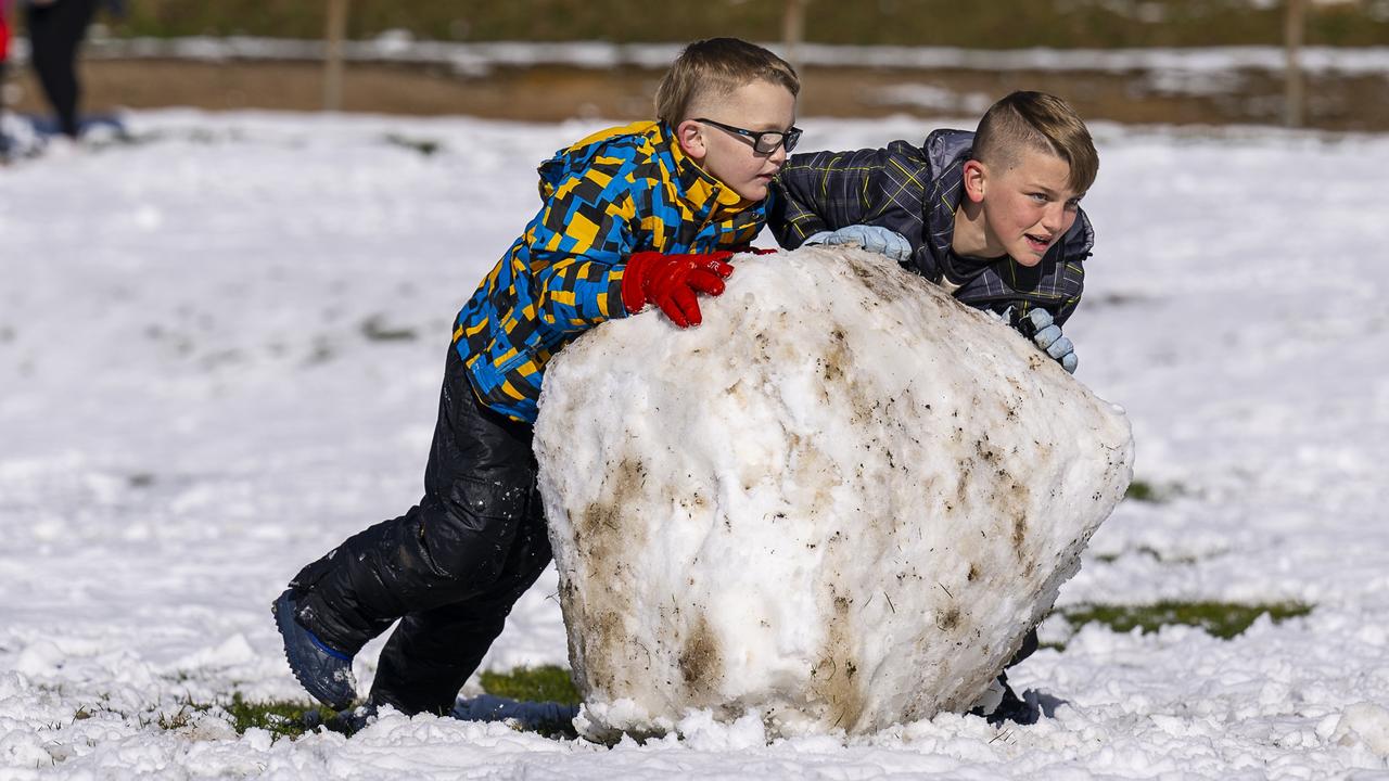 Lucas and Tyler Davies in Katoomba with a snowman under construction. Picture Simon Carter