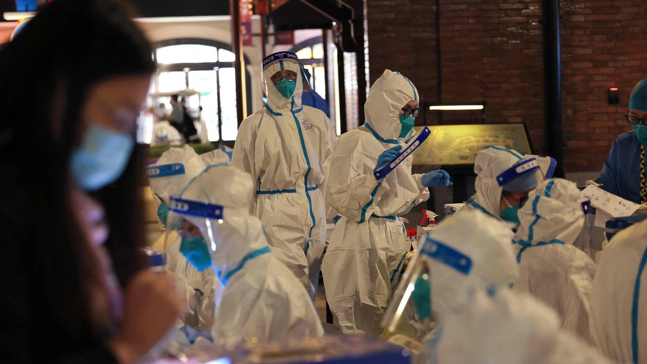 This photo taken on October 31, 2021 shows medical personnel preparing to test visitors for the Covid-19 coronavirus at Disneyland in Shanghai after a single coronavirus case was detected at the park on the weekend. (Photo by AFP) / China OUT